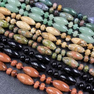Détail de colliers en perles de pierre naturelle avec agate en tour et cristaux colorés