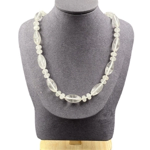 Vue détaillée du collier en perles de cristal transparent sur un présentoir gris