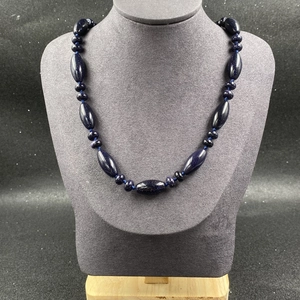 Détail du collier en pierre de sable bleu avec perles ovales et rondes sur support gris