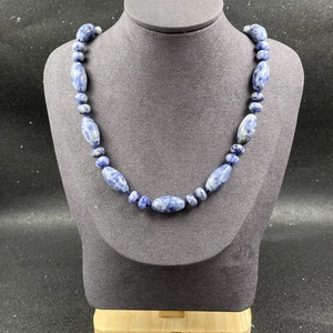 Vue détaillée du collier en pierre naturelle bleue et blanche sur buste gris