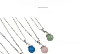 Detail view of colorful crystal sphere pendants with silver witch hat caps on fine chains