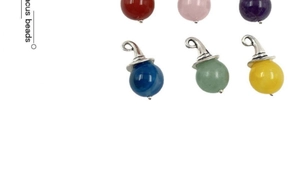 Close-up of wizard hat shaped metal caps on colorful assorted natural gemstone beads