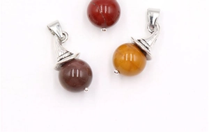 Detailed view of assorted natural gemstone sphere pendants with silver witch hat clasps