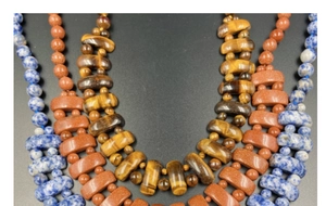 Détail de perles en oeil de tigre, sodalite et pierre de soleil sur colliers multicouches