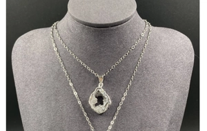 Detail of silver plated natural druzy agate slice pendant on display stand