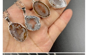 Macro detail of natural Brazilian agate geode pendants with silver plating and crystal clusters