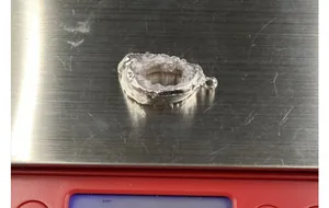 Macro shot of a natural druzy agate slice pendant on a digital scale weighing 32.5g