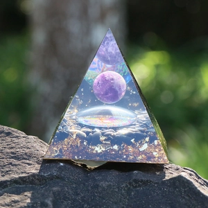 Orgon-Pyramide mit Amethyst-Kugel, Kunstharz-Goldfolie und Heilkristallen auf Naturstein