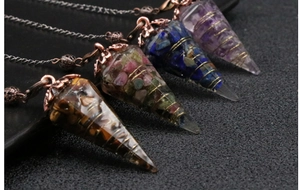 Detail of four handmade crystal cone pendants with gold wire wrap on dark background