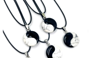Detail of Tai Chi Yin Yang necklace with black polished stone and white marble texture