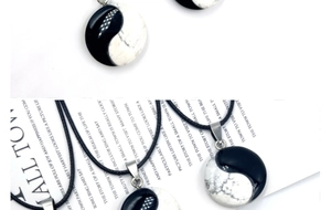Macro shot of Yin Yang pendant with black agate and white marble stone textures