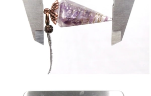Measuring the size of amethyst resin pendulum with calipers for spiritual dowsing