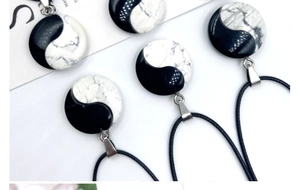 Detailed shot of Yin Yang Tai Chi pendants with natural white turquoise and black stone