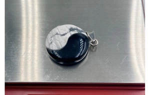 Macro detail of Yin Yang Tai Chi pendant crafted from natural agate and turquoise stone