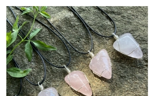 Détails de colliers en quartz rose faits main sur fond de pierre naturelle grise