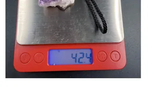 Bilancia che misura il peso di 42,4g di un ciondolo a grappolo di ametista naturale