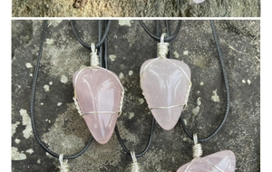 Gros plan du pendentif en quartz rose en forme de cœur avec fil d'argent torsadé