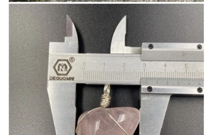 Mesure de la largeur du pendentif en quartz rose indiquant environ 2,5 cm au pied à coulisse