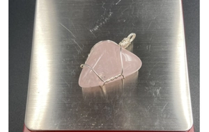 Vue détaillée du pendentif en quartz rose naturel enveloppé de fil métallique triangulaire