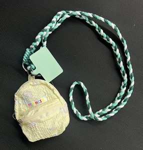 Detailed close-up of a mini backpack coin purse with textured seersucker fabric and woven lanyard