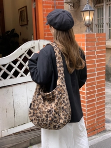 Faux fur leopard print tote bag styled with a black blazer in a retro street setting