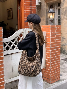 Detail of plush leopard print tote bag with soft faux fur texture and large hobo capacity