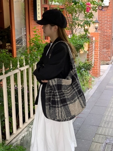 Outdoor street style shot of a large black and white checkered fuzzy tote bag