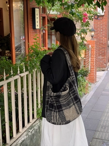 Detail shot of a large grey plaid tote bag in soft wool fabric for autumn fashion