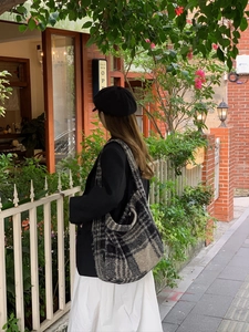Fashionable black and grey plaid tote bag styled with a blazer for a casual street look