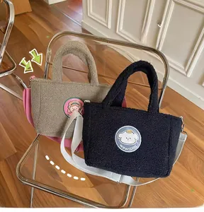 Detail of khaki and black fleece tote bags with embroidery and adjustable straps
