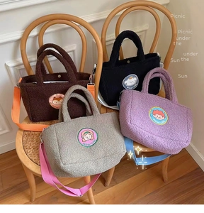 Detail view of colorful lamb wool tote bags in four shades on vintage wooden chairs