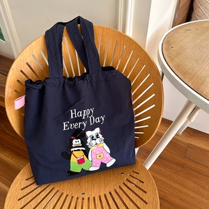 Detail der dunkelblauen Nylon-Tasche mit Cartoon-Motiv und Happy Every Day Schriftzug
