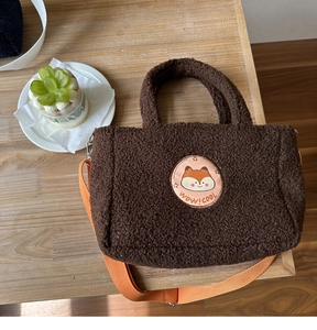 Detail of soft brown fleece tote bag with cute fox patch and orange shoulder strap