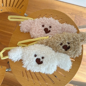 Detailed macro view of three plush poodle pouches in pink, brown, and white soft faux fur