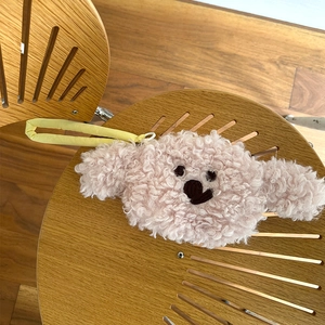 Close-up of pink plush bear coin purse with curly faux shearling texture and yellow strap