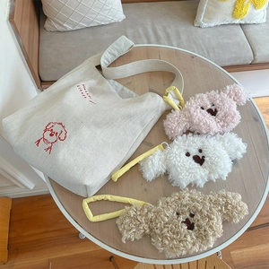 Off-white canvas tote with cute dog embroidery and three colorful plush puppy charms