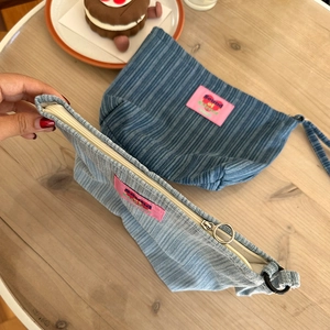 Corduroy zipper pouches in navy and light blue with Sound of Silence label on wooden desk