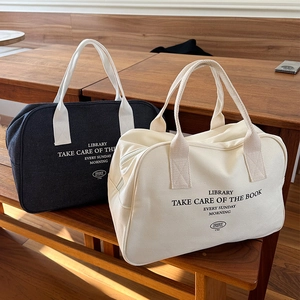 Close-up of canvas boston bags in black and beige with library letter print