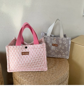 Close-up of floral jacquard fabric and leather logo on portable lunch bags