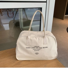 Detailed view of the Boston canvas bag with black letter print on a wooden desk