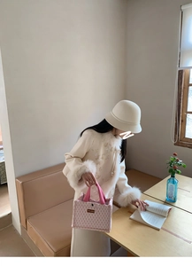Pink quilted tote bag with double handles shown in a cozy cafe setting with flowers