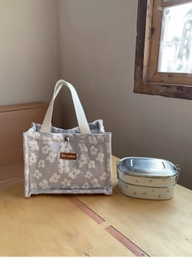 Blue-grey lunch bag with white floral embroidery and stainless steel food container