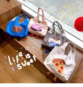 Detailed view of canvas tote bags with cartoon food prints and 3D stuffed feet decor