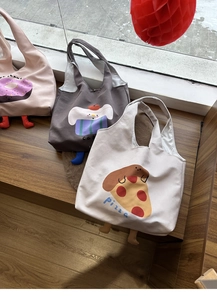 Detailed view of canvas tote bags with cartoon patterns and 3D stuffed feet decorations