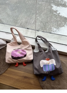 Detail of canvas tote bags featuring 3D plush legs and cute doughnut and cake illustrations