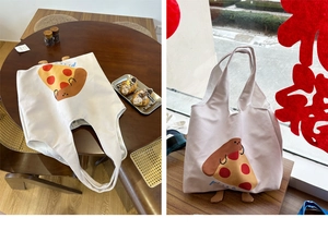 Detail of canvas tote bag with cute pizza print and reinforced handles for daily use