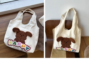 Detailed view of plush 3D puppy patch and colorful HAPPY embroidery on canvas tote bag