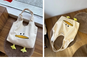 Close-up of canvas tote bag featuring cute plush duck feet and simple duck face design
