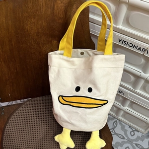 Detail shot of cute 3D plush duck feet and embroidery on the canvas tote bag base