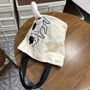 Detail of cute cat embroidery on cream canvas tote with a 3D fluffy white plush tail